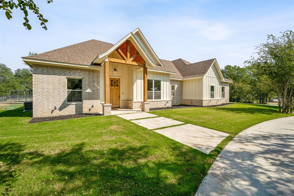 a front view of a house with a yard and trees