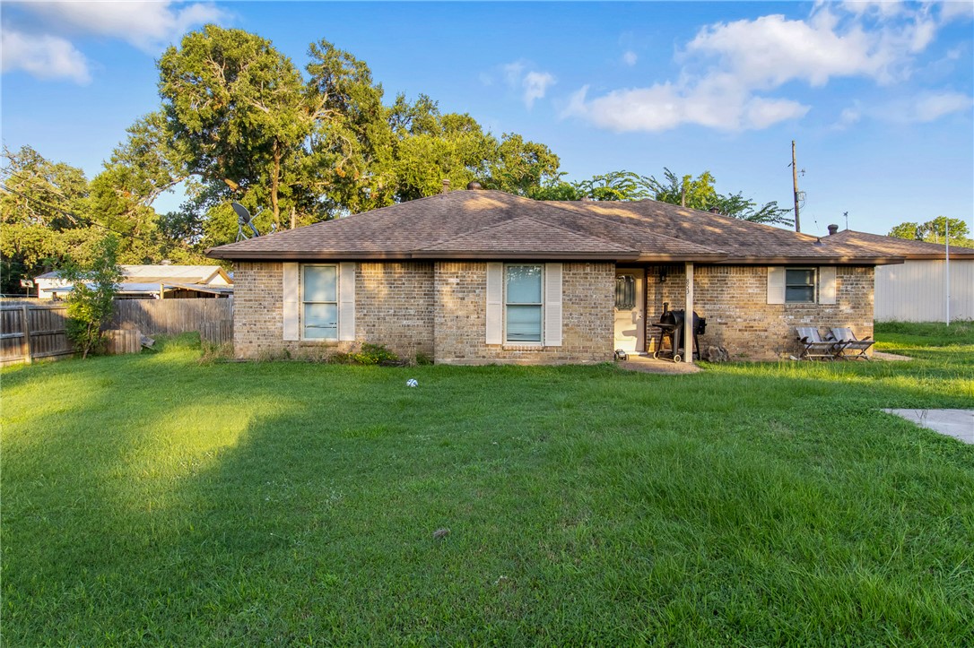 Rear view of house with a yard