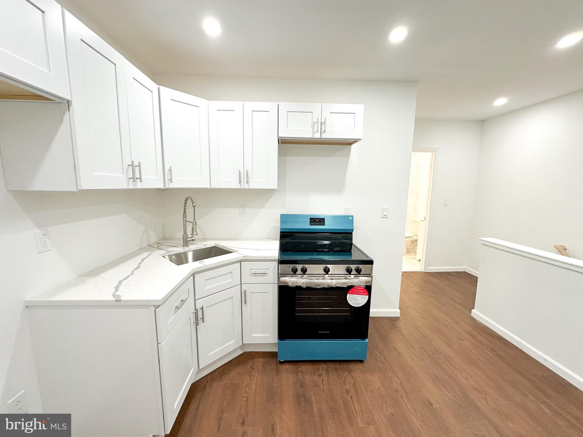 a kitchen with a stove a sink and a refrigerator