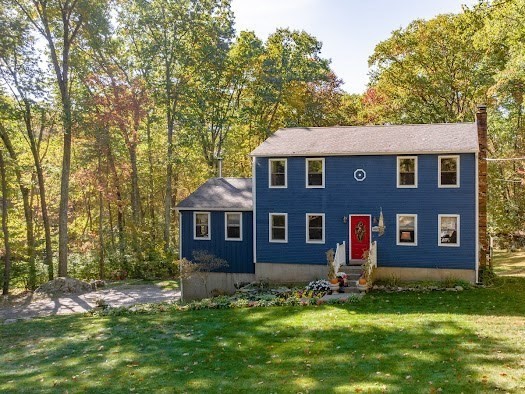 a brick house that has tree in front of it