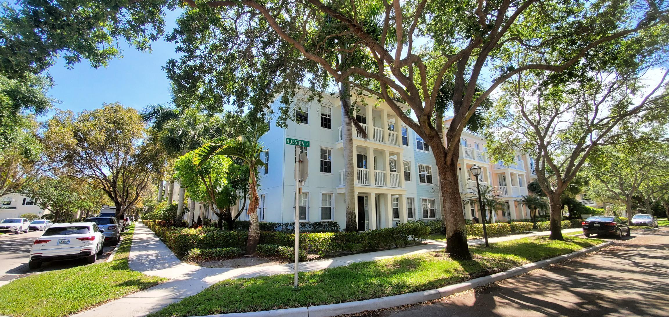 a view of a building with a yard and trees