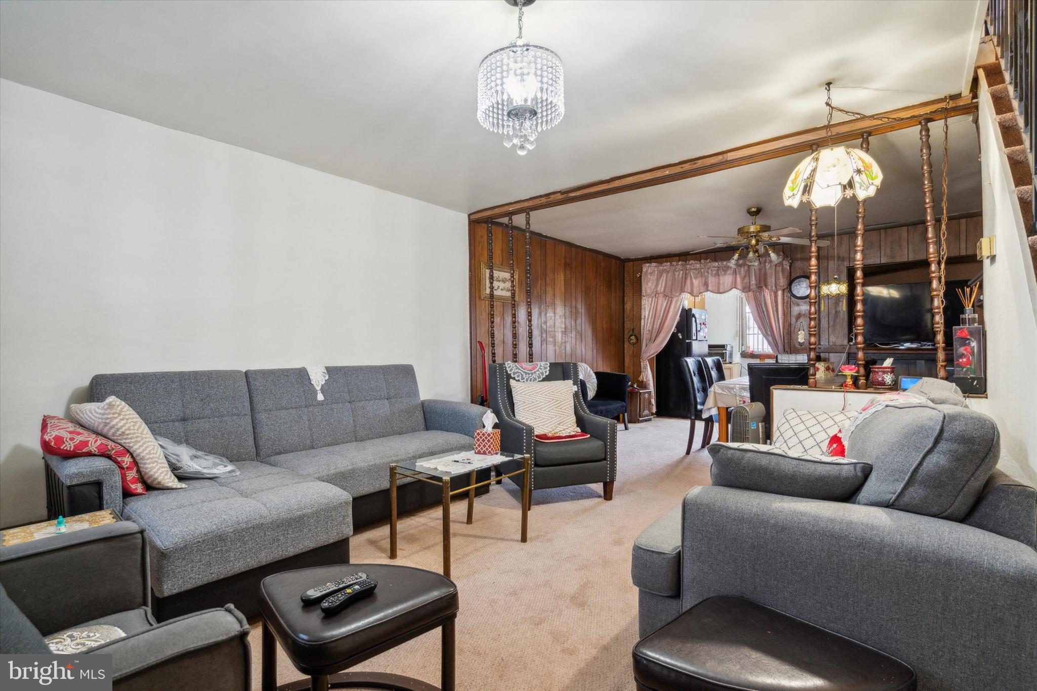 a living room with furniture a dining table and a chandelier