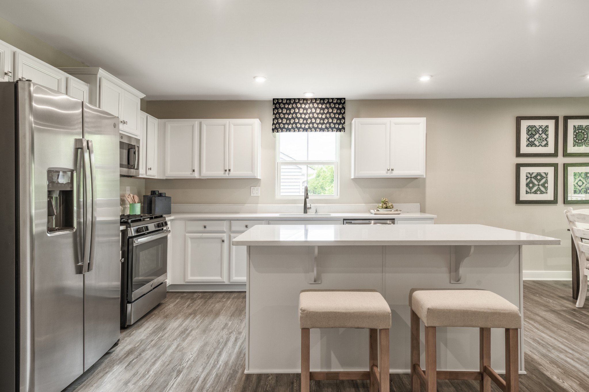 a kitchen with a sink a refrigerator and white cabinets