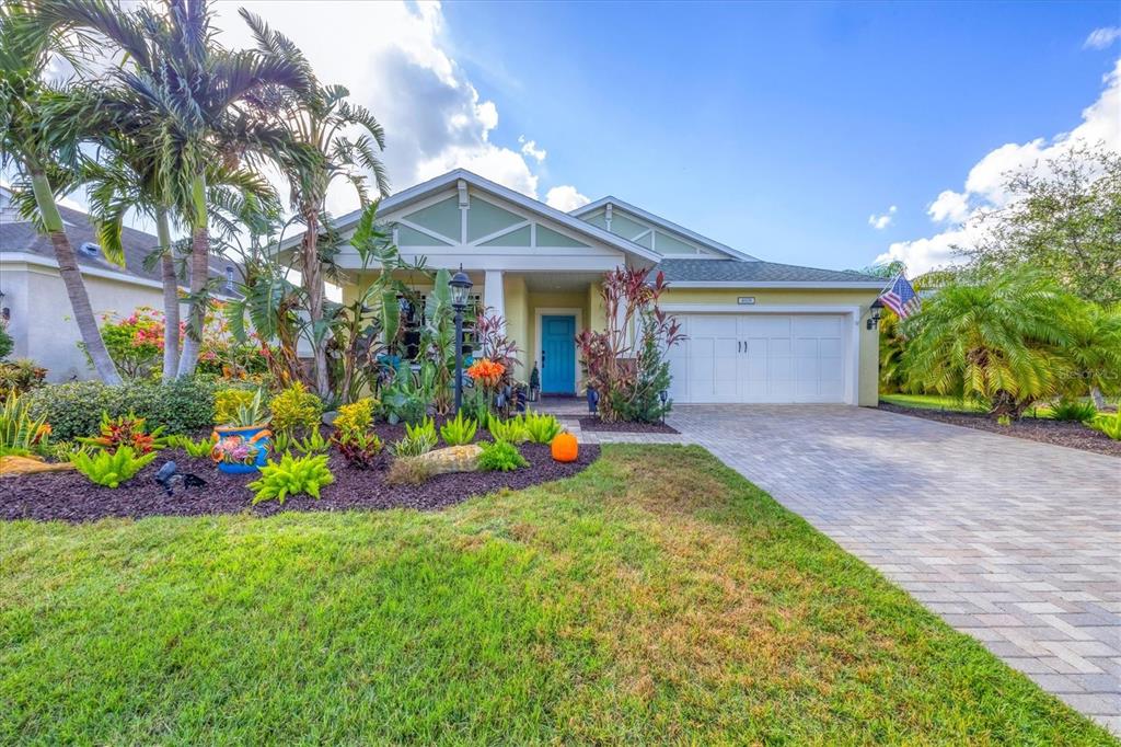 a view of a house with a yard and potted plants