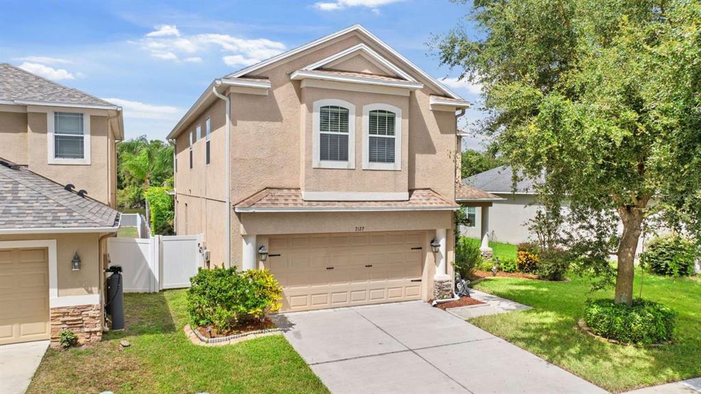 a front view of a house with a yard and garage