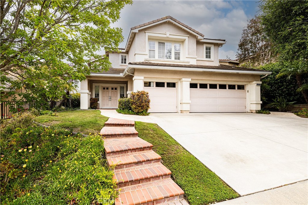 a front view of a house with a yard and trees