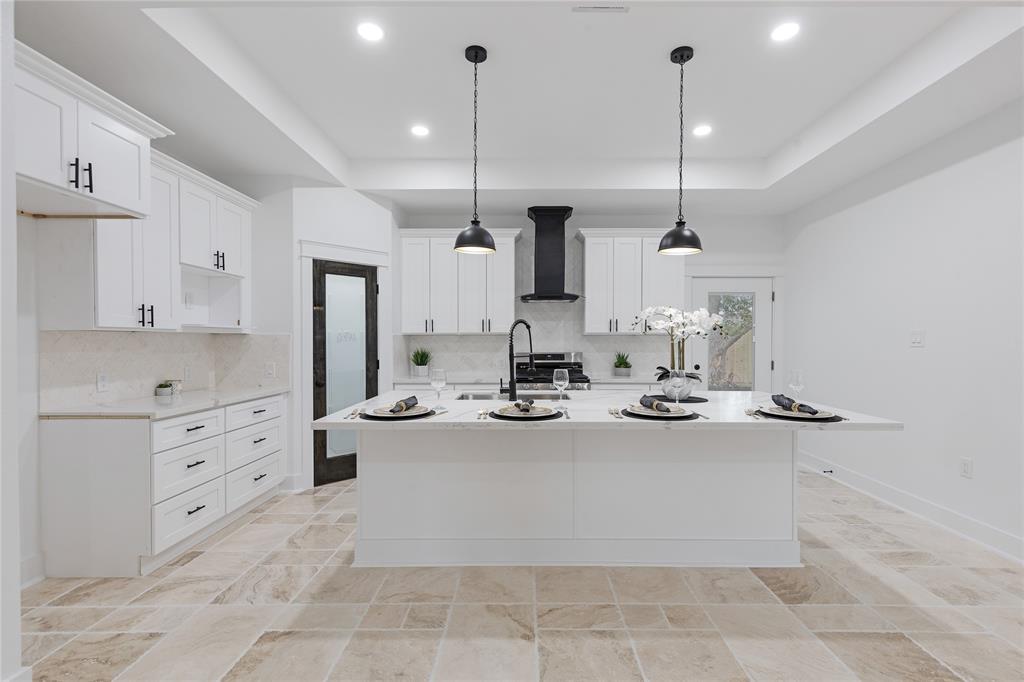 a large kitchen with kitchen island a stove a sink a center island and cabinets