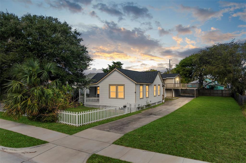 a front view of a house with a garden and yard