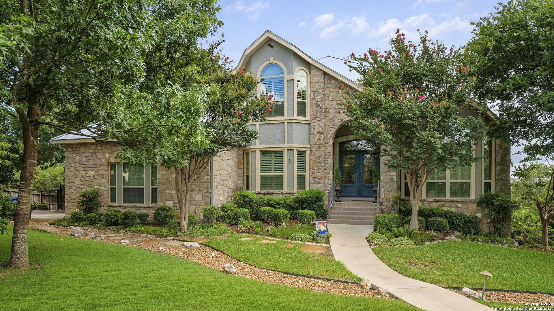 a front view of a house with a yard and potted plants