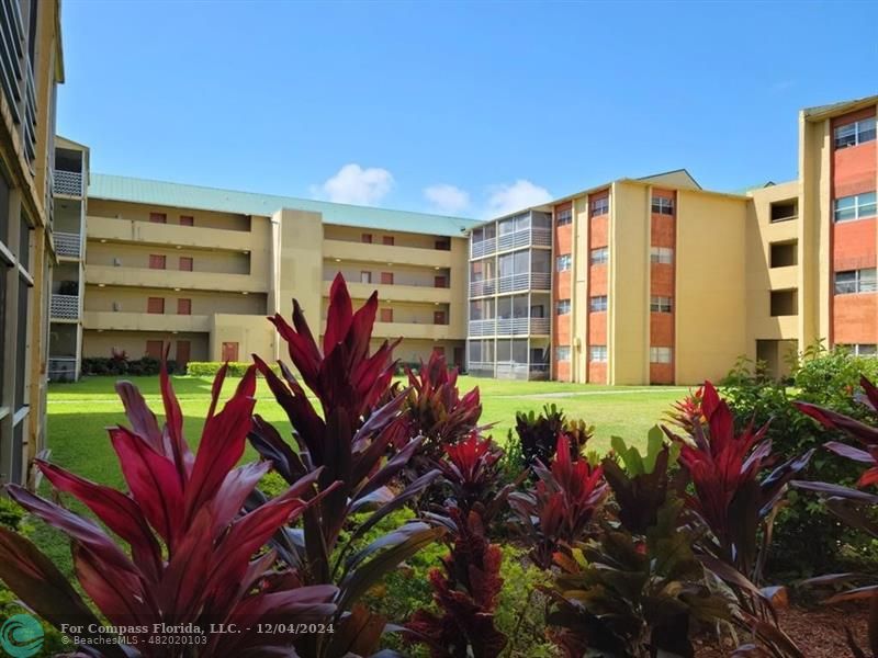 a front view of multi story residential apartment building with yard