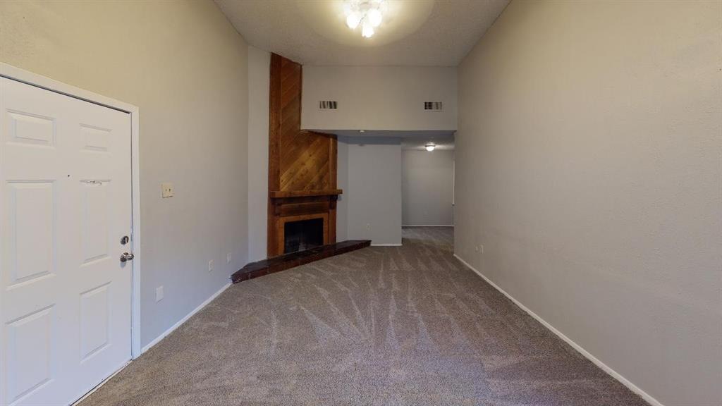 a view of an empty room with a fireplace