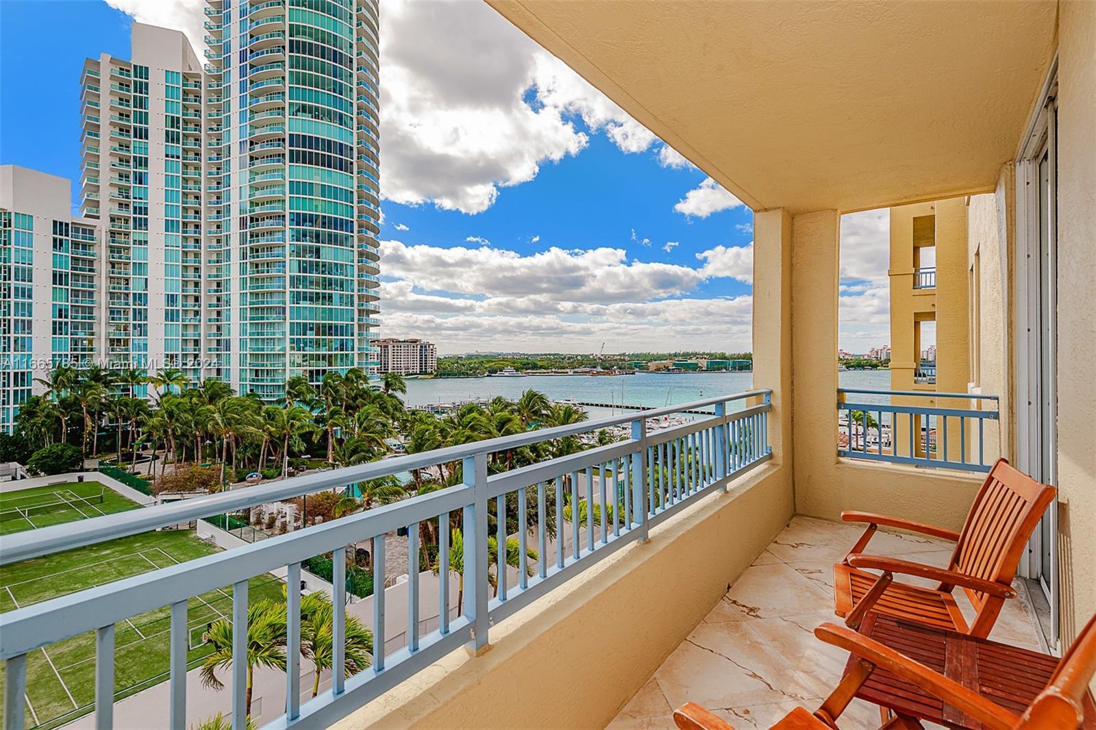 a view of a city from a balcony with chairs