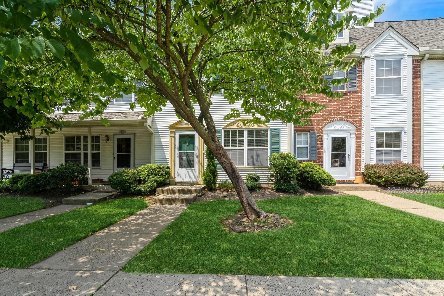 a front view of a house with a yard and green space