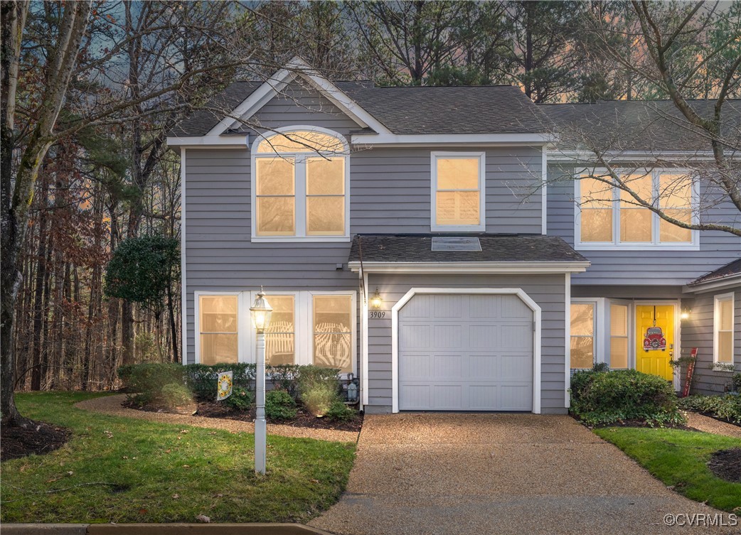 Front of house featuring 1 car garage and paved pa