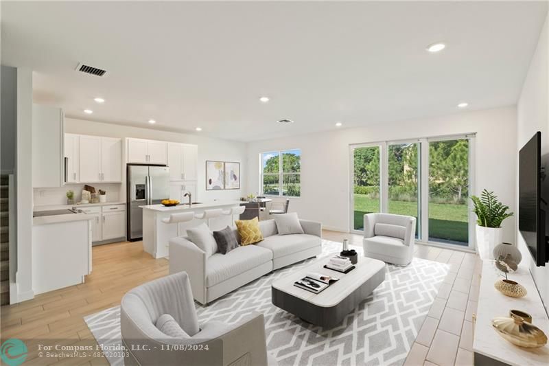 a living room with furniture flat screen tv and a large window