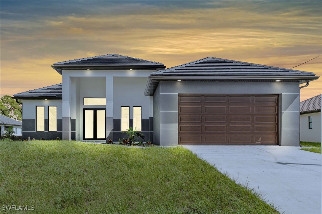 a front view of a house with a yard and garage