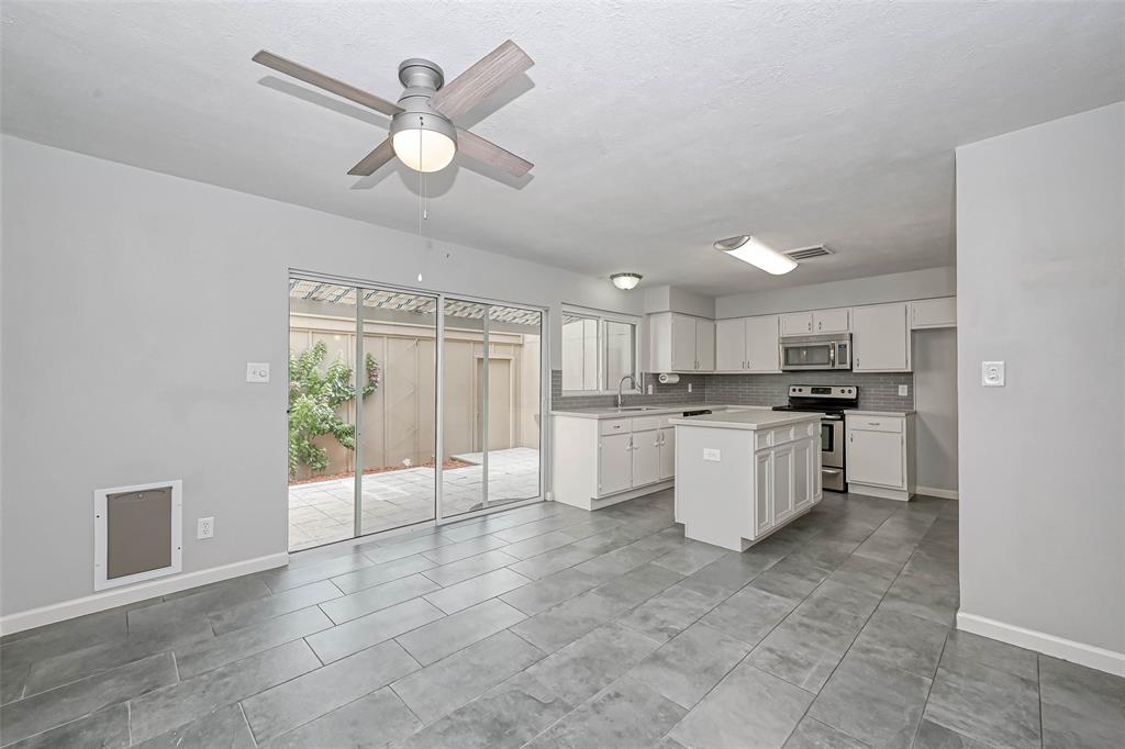 NICELY UPDATED KITCHEN WITH ISLAND, QUARTZ COUNTERTOPS AND SS APPLIANCES