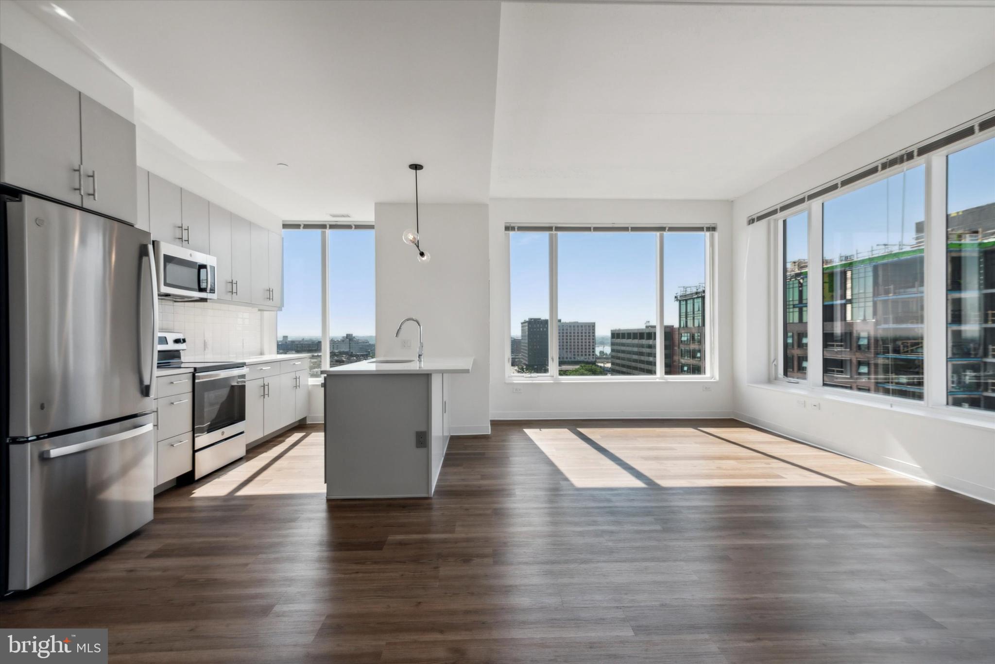 a view of kitchen with refrigerator and wooden floor