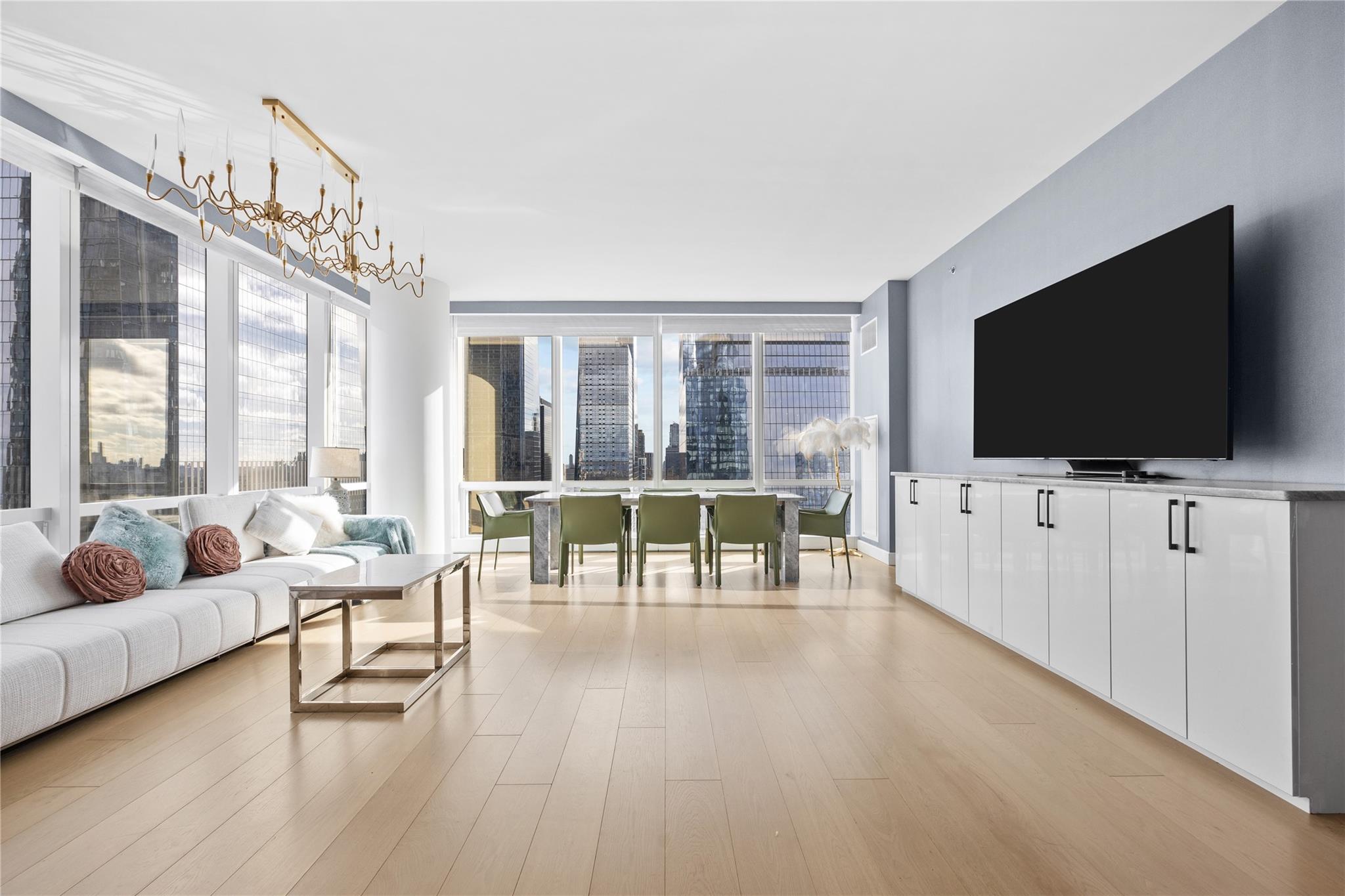 Living room featuring light wood-type flooring and an inviting chandelier