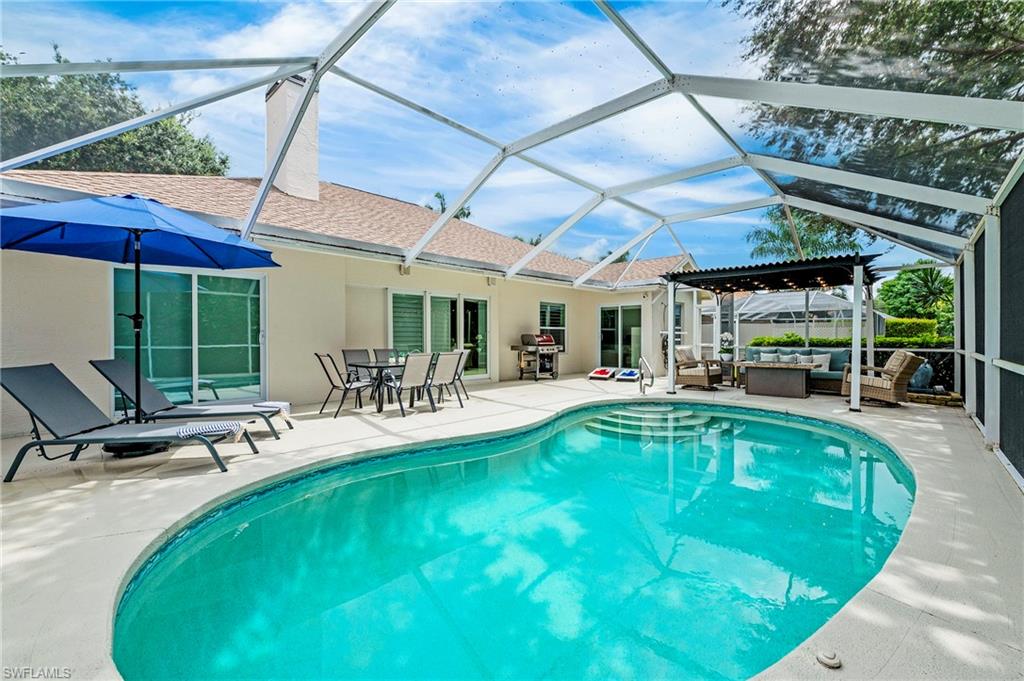 a view of a swimming pool with a patio and lawn chairs