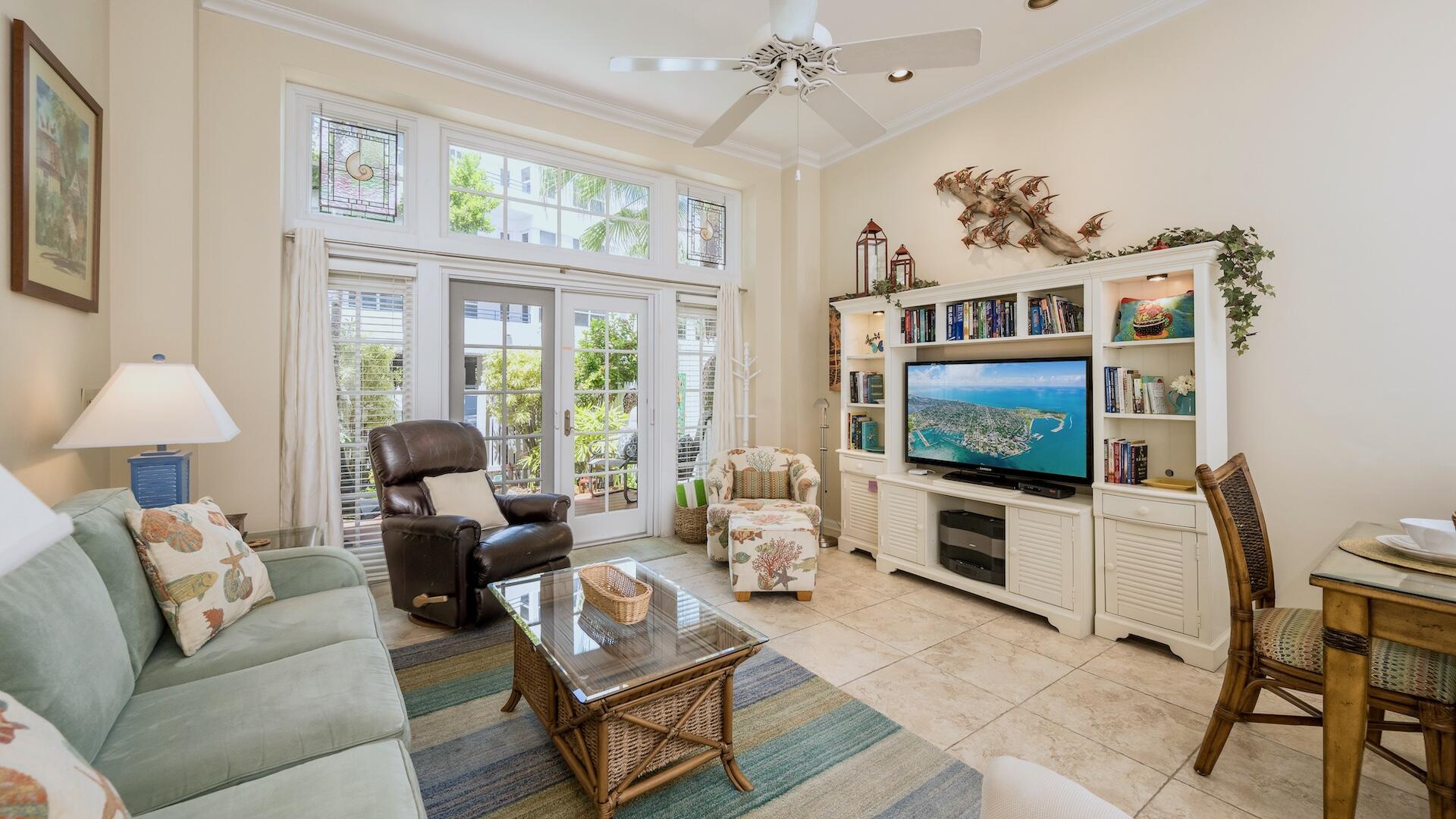 a living room with furniture a chandelier and a flat screen tv