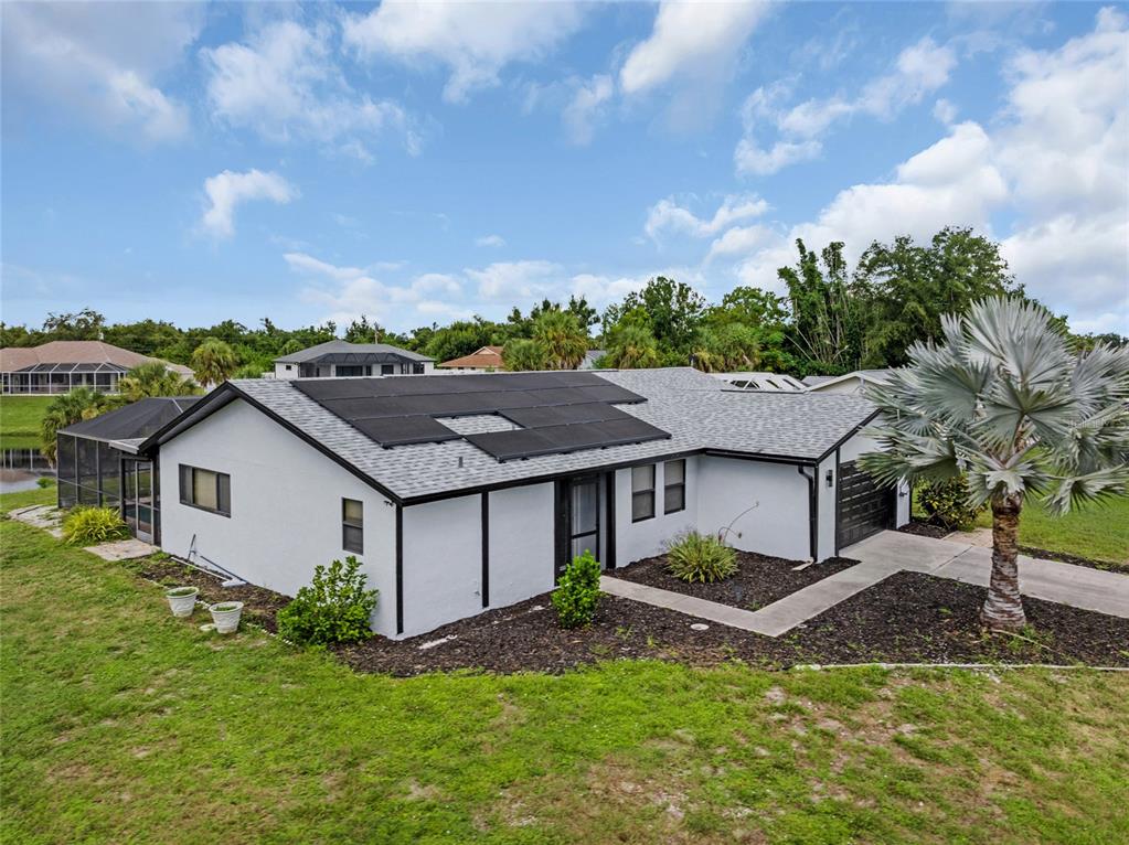 a aerial view of a house with a yard and a large tree