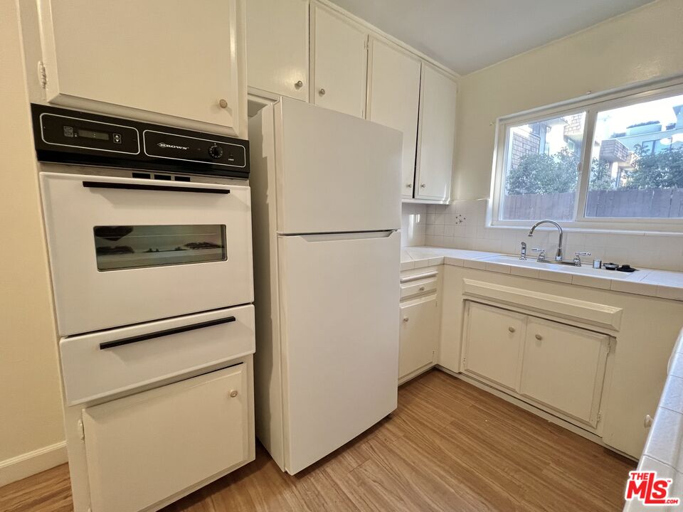 a kitchen with a white cabinets and white appliances