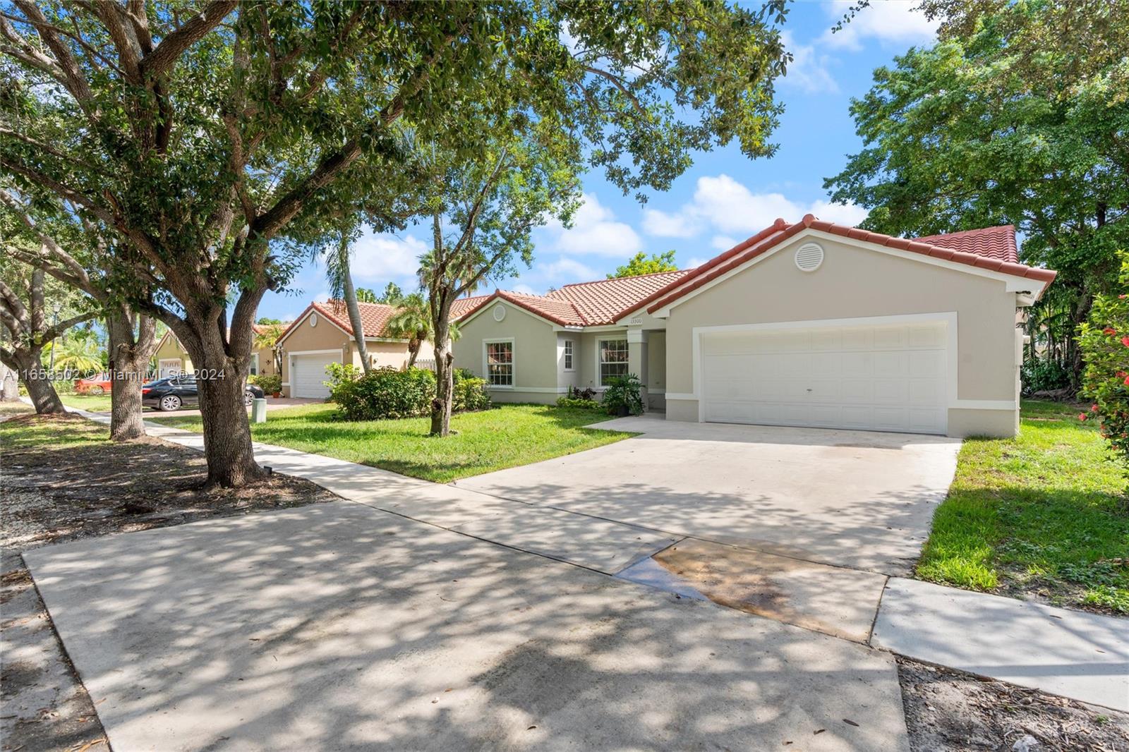 a view of a house with a big yard and large trees