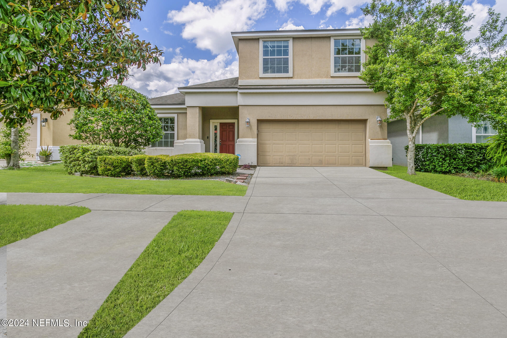 a front view of a house with a yard and a garage