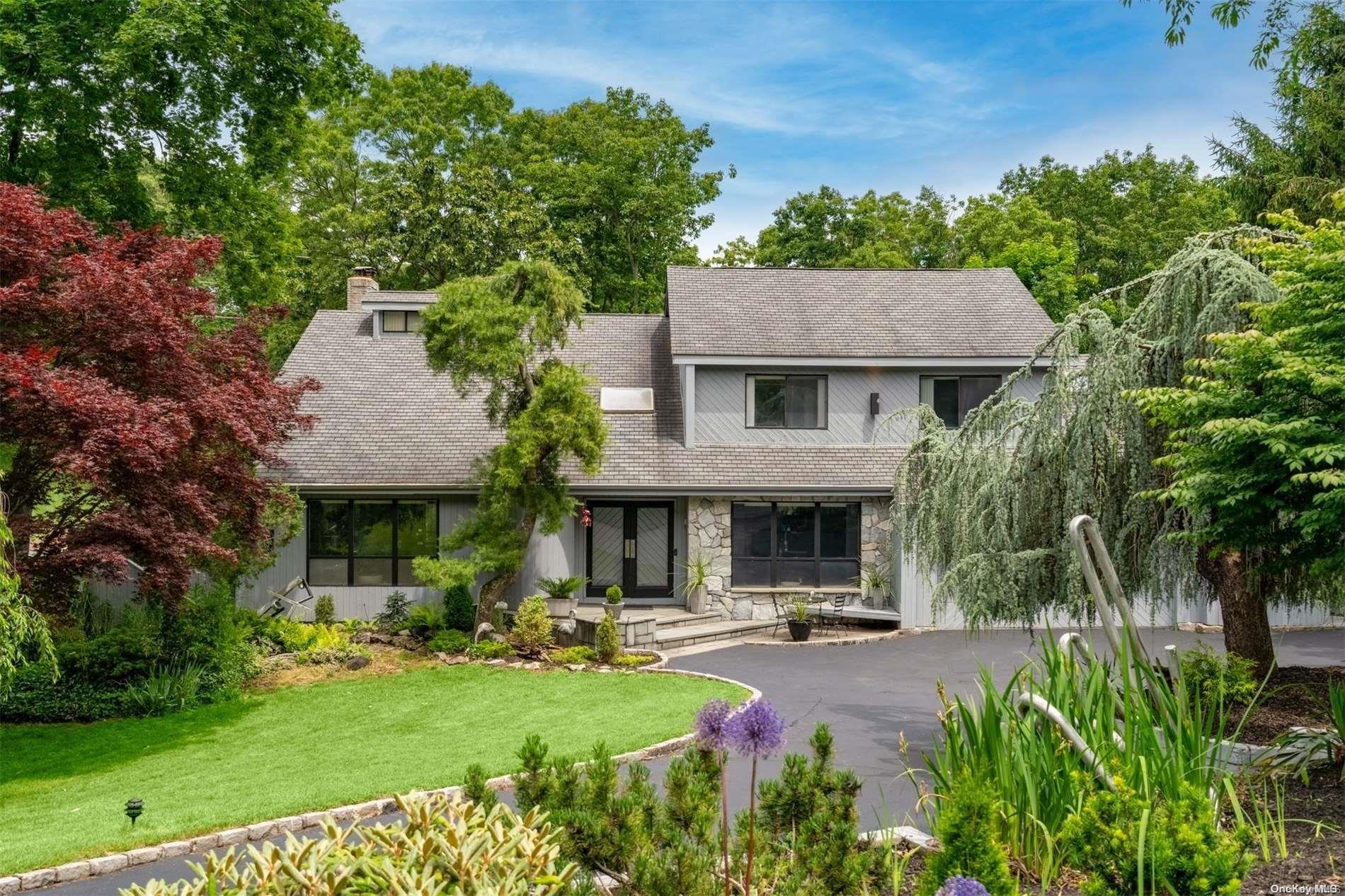 a front view of a house with yard and green space