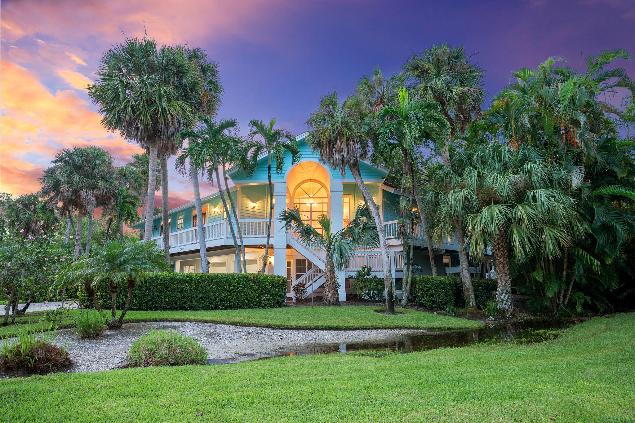 a front view of a house with a garden and trees