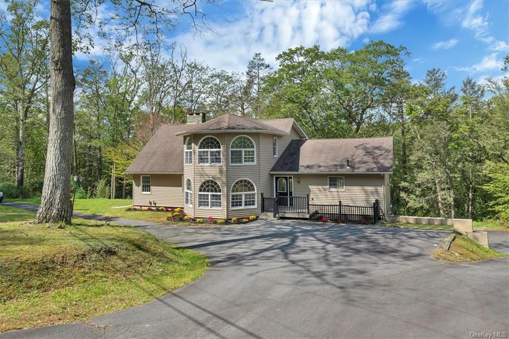 View of front of property with a wooden deck and a front yard