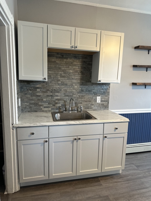 a kitchen with white cabinets and sink