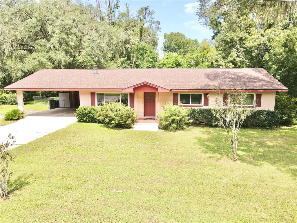 a front view of house with yard and trees around