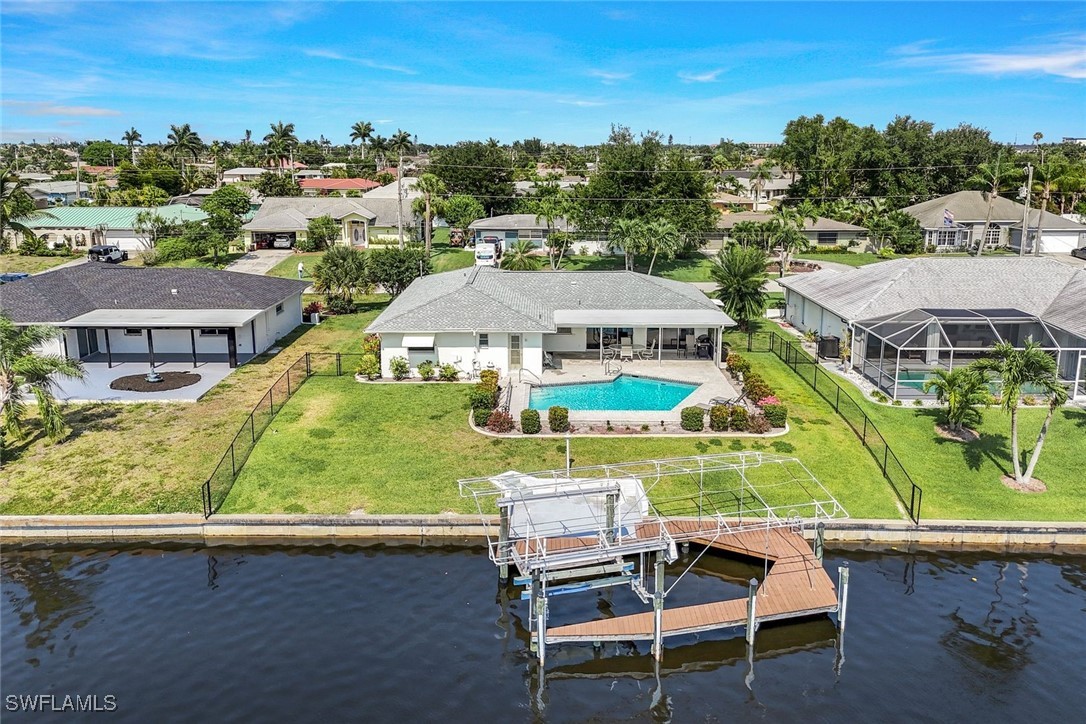 an aerial view of residential houses with outdoor space and ocean view