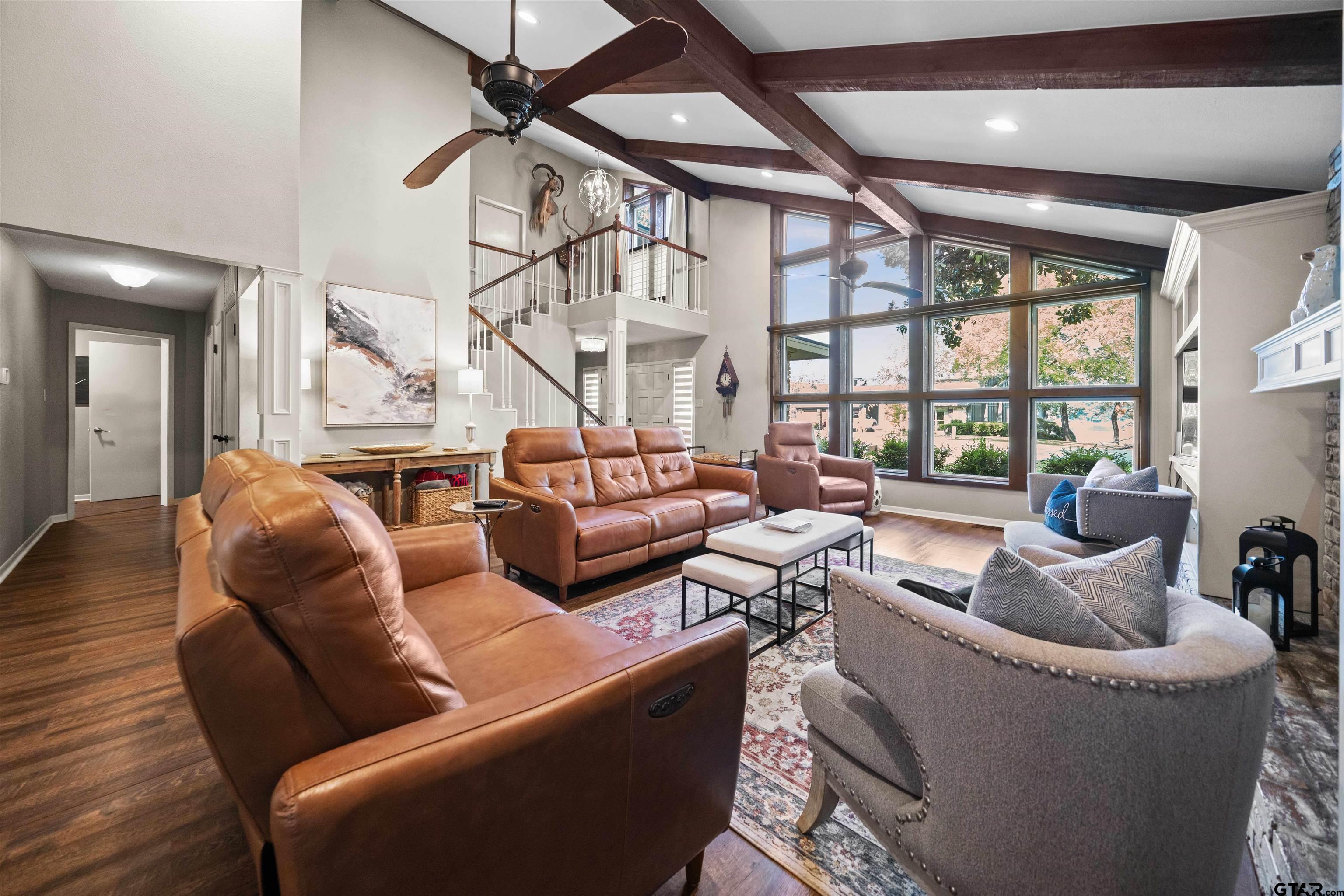 a living room with fireplace furniture and a large window