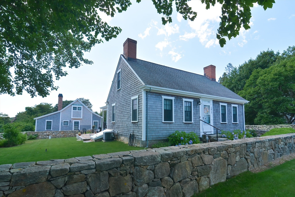 a front view of a house with a garden and plants