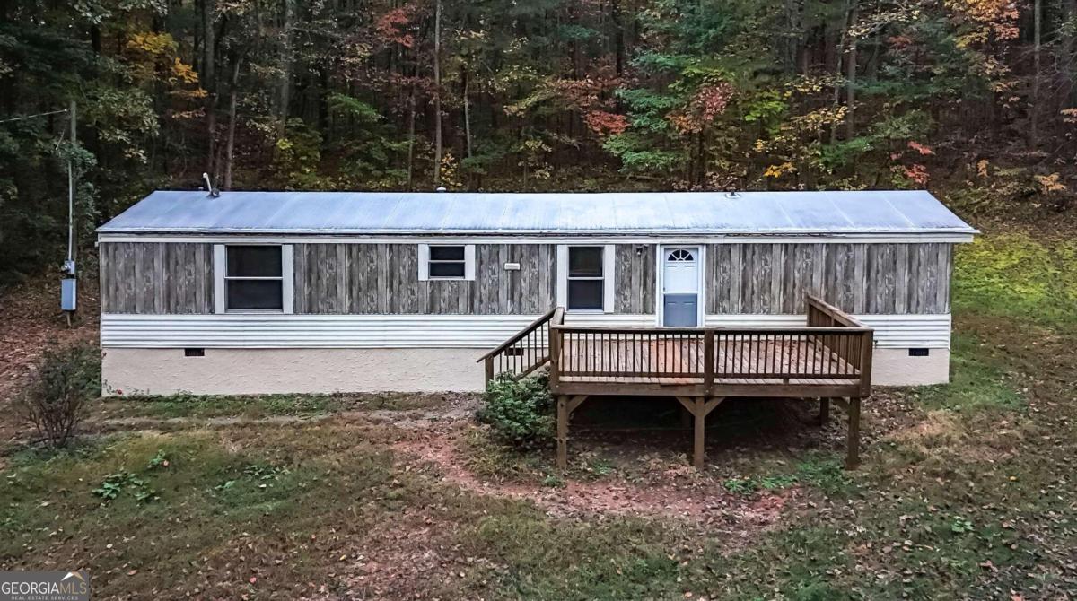 a view of a house with a wooden deck and a yard