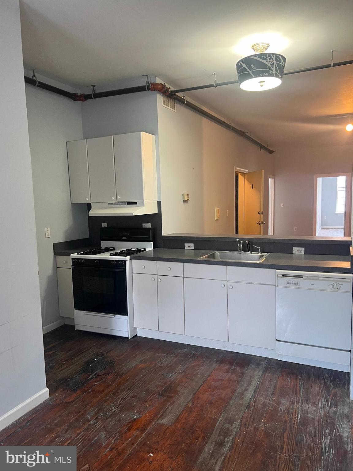 a kitchen with granite countertop white cabinets and black appliances