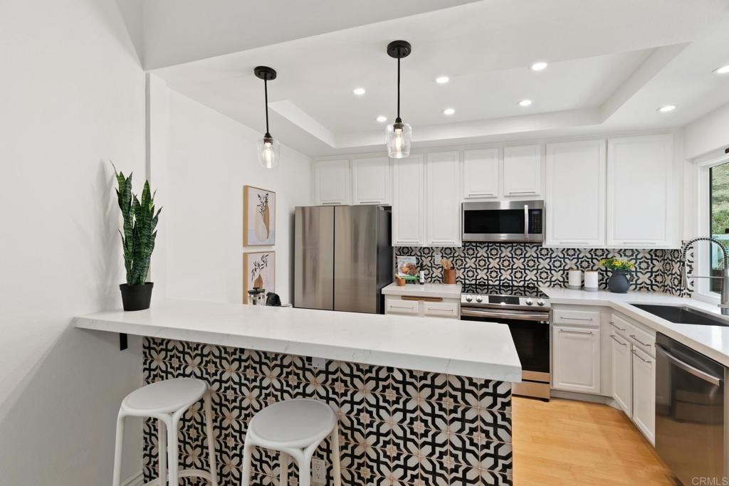 a kitchen with a sink stainless steel appliances and white cabinets