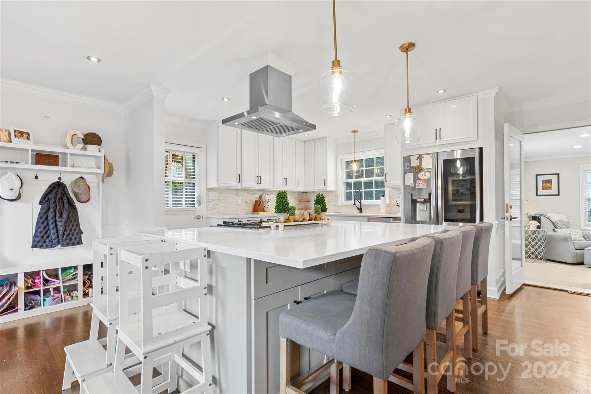 a kitchen with stainless steel appliances granite countertop a table chairs and a view of living room