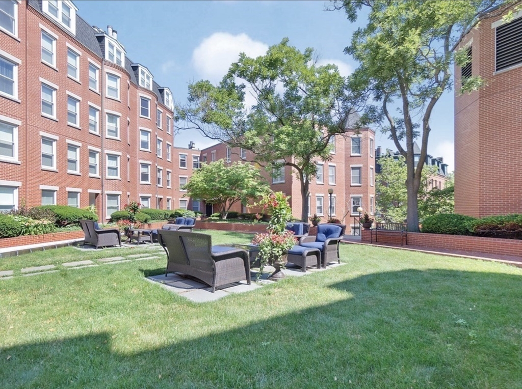 a view of a building with a garden and chairs