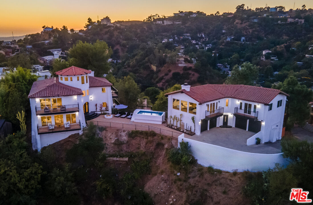 a front view of a house with a yard and mountain view in back