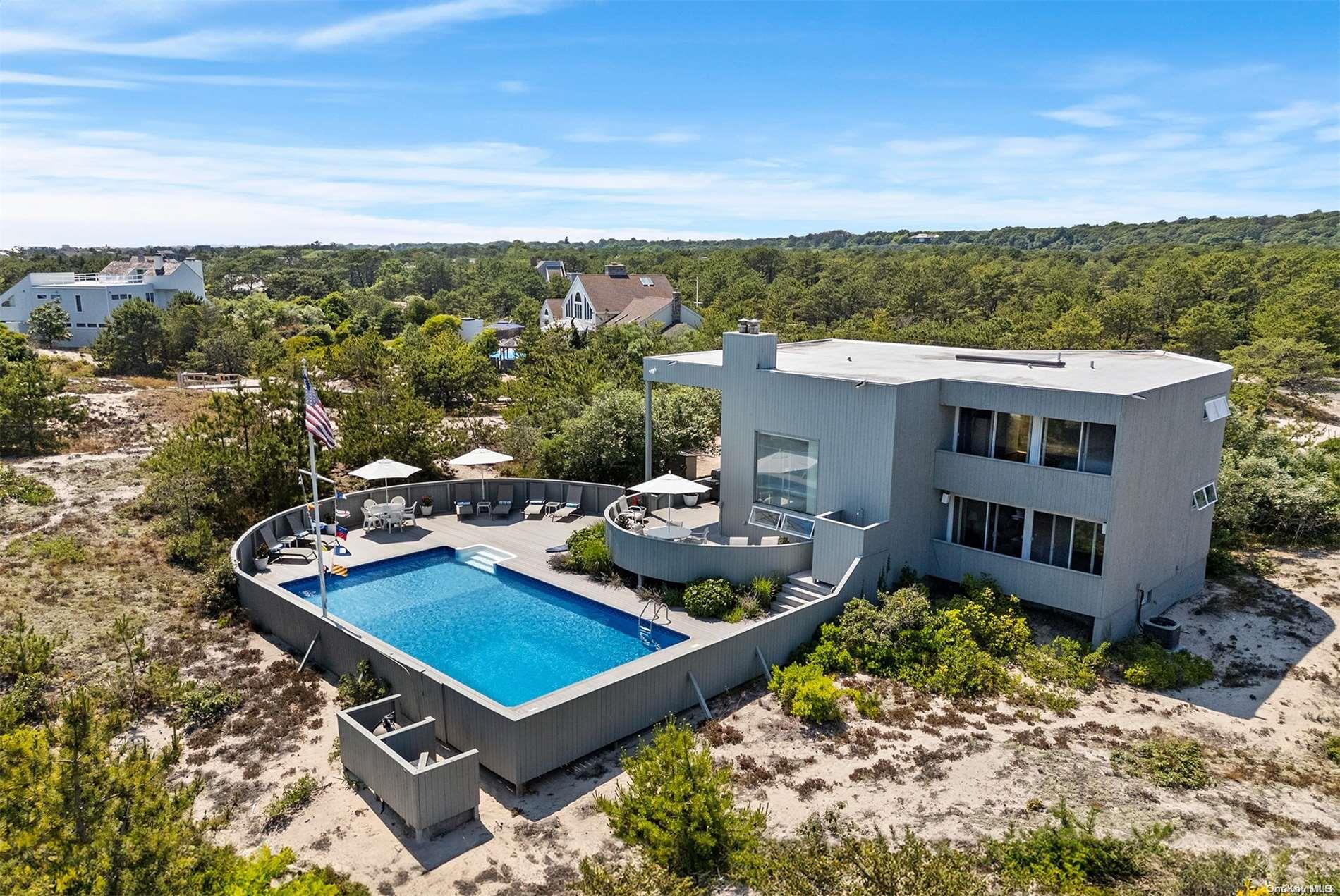 an aerial view of a house with a garden and lake view