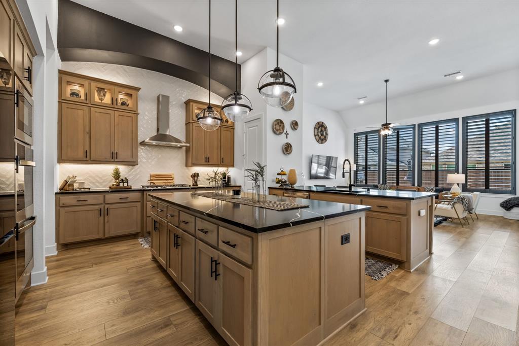 a kitchen with a sink stove and wooden floor