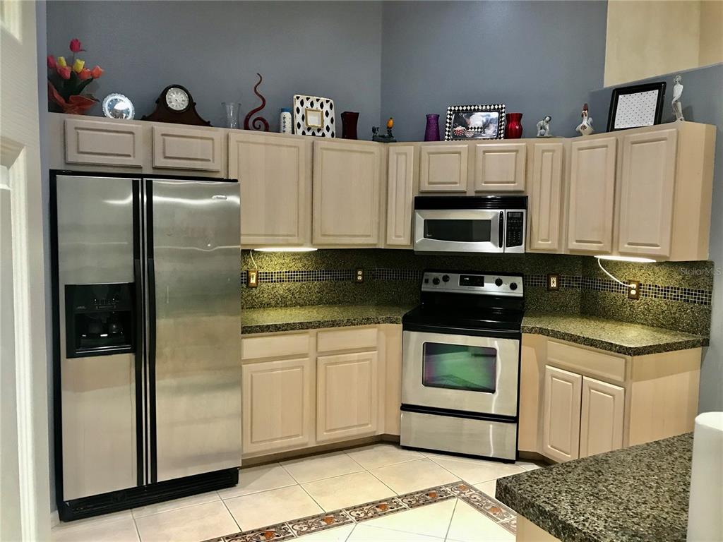 a kitchen with stainless steel appliances granite countertop a refrigerator sink and stove