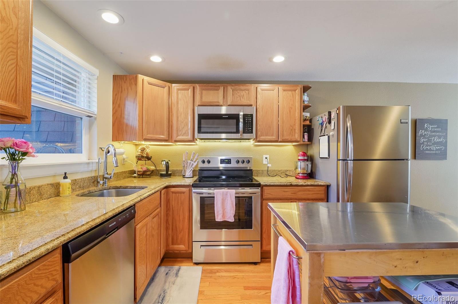 a kitchen with a sink a stove a refrigerator and a window