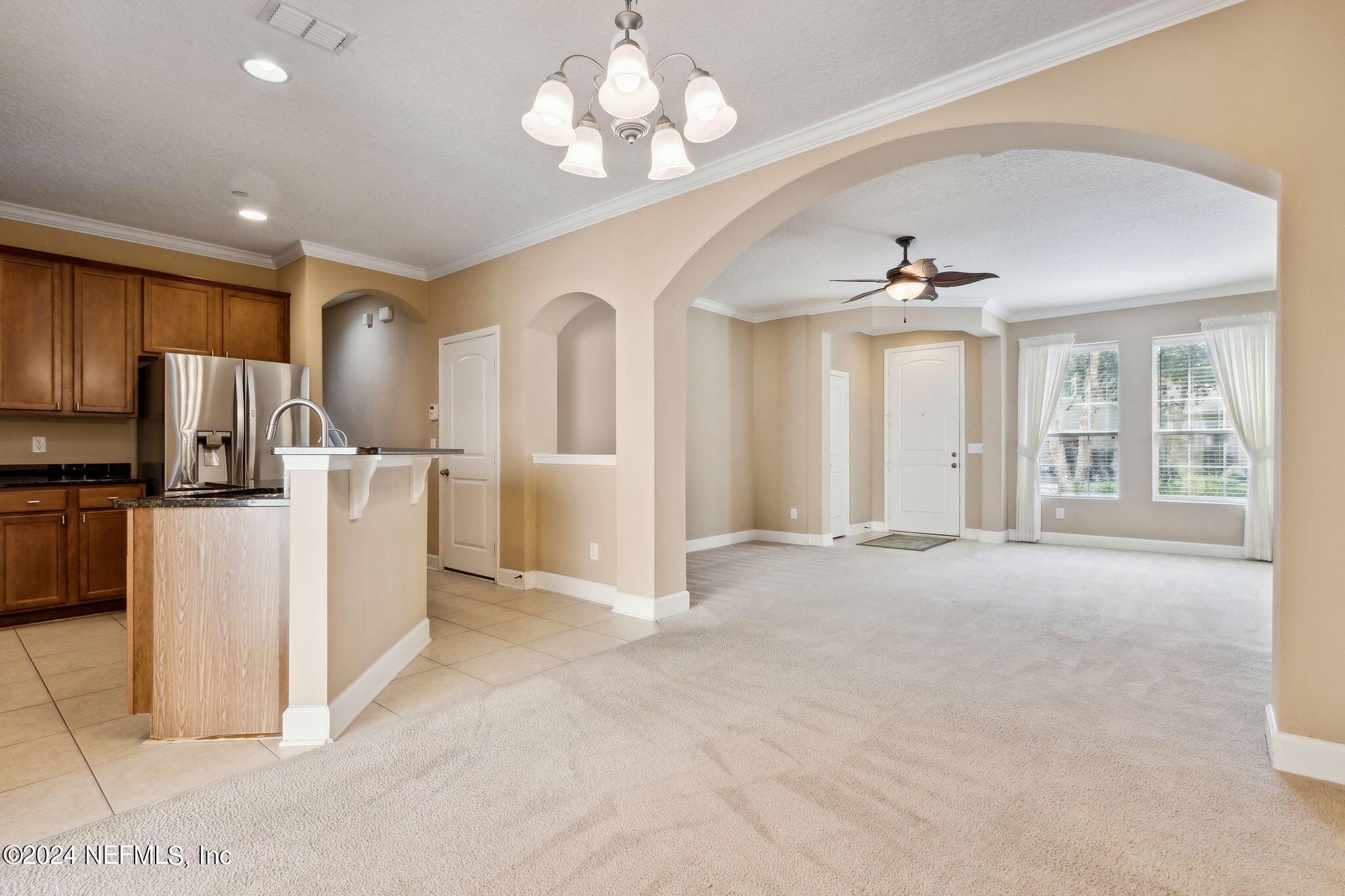 a view of a livingroom with a chandelier furniture and a kitchen