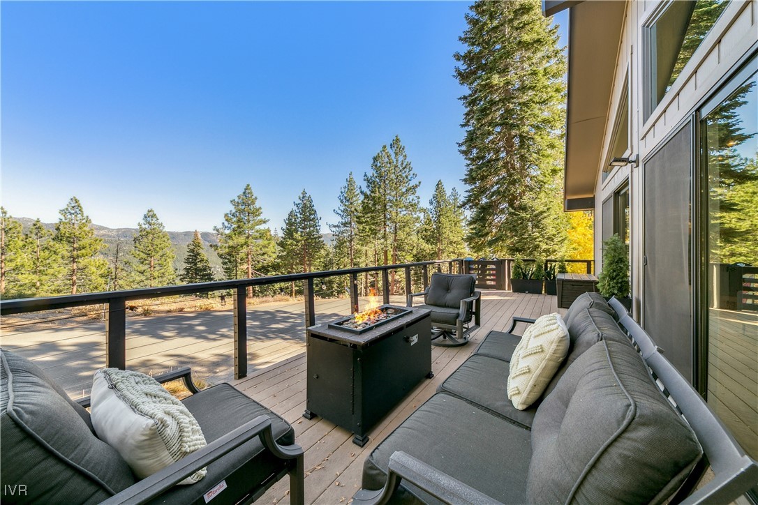 a balcony with wooden floor and outdoor seating