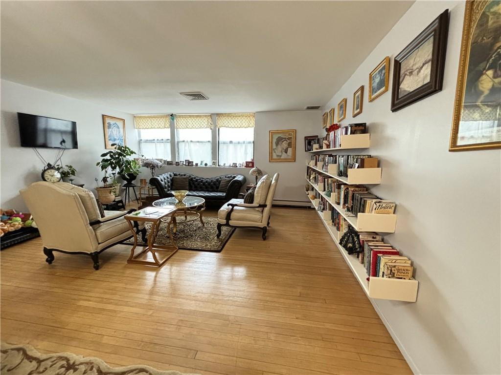 Living room featuring baseboard heating and light hardwood / wood-style floors